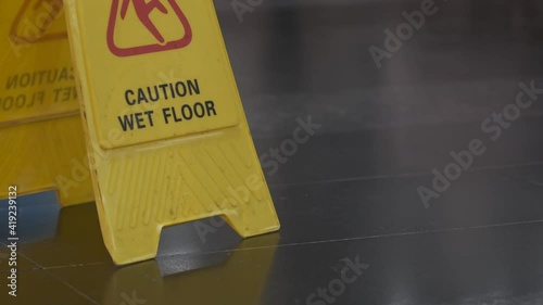 Sign Caution Wet Floor. Yellow plaque in the mall.
