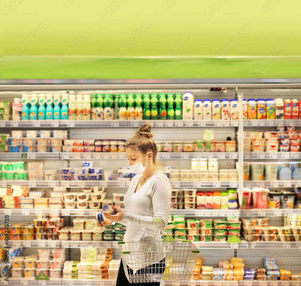 supermarket shopping, face mask and gloves,Woman choosing a dairy products at supermarket supermarket shopping, face mask and gloves,Woman choosing a dairy products at supermarket