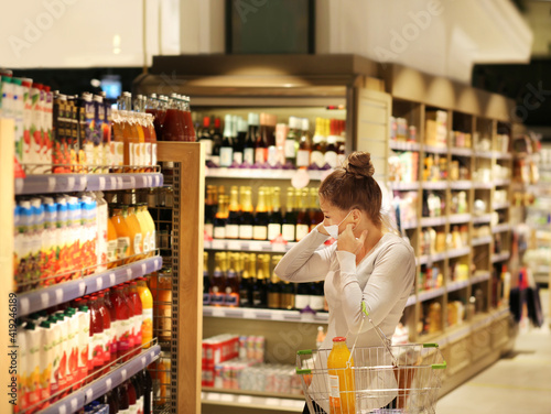 supermarket shopping, face mask and gloves,Woman choosing a dairy products at supermarket © lado2016