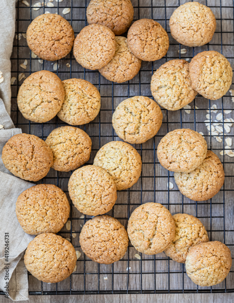 Oatmeal cookies on black metal grille, wooden background. Healthy vegan cookies. Top view. Oatmeal cookies on black metal grille, wooden background. Healthy vegan cookies. Top view.