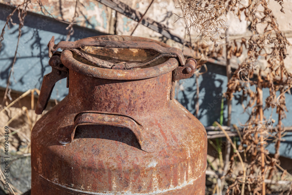 Old rusty metal milk jug.