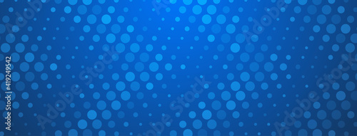 Abstract halftone background made of dots of different sizes in blue colors