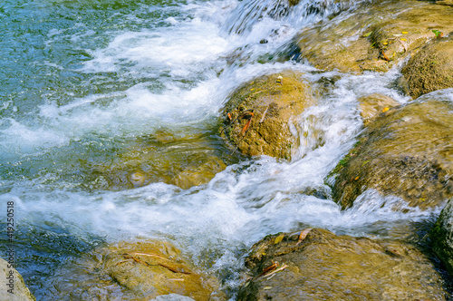 Rock stone in the water covered by moist fresh green moss