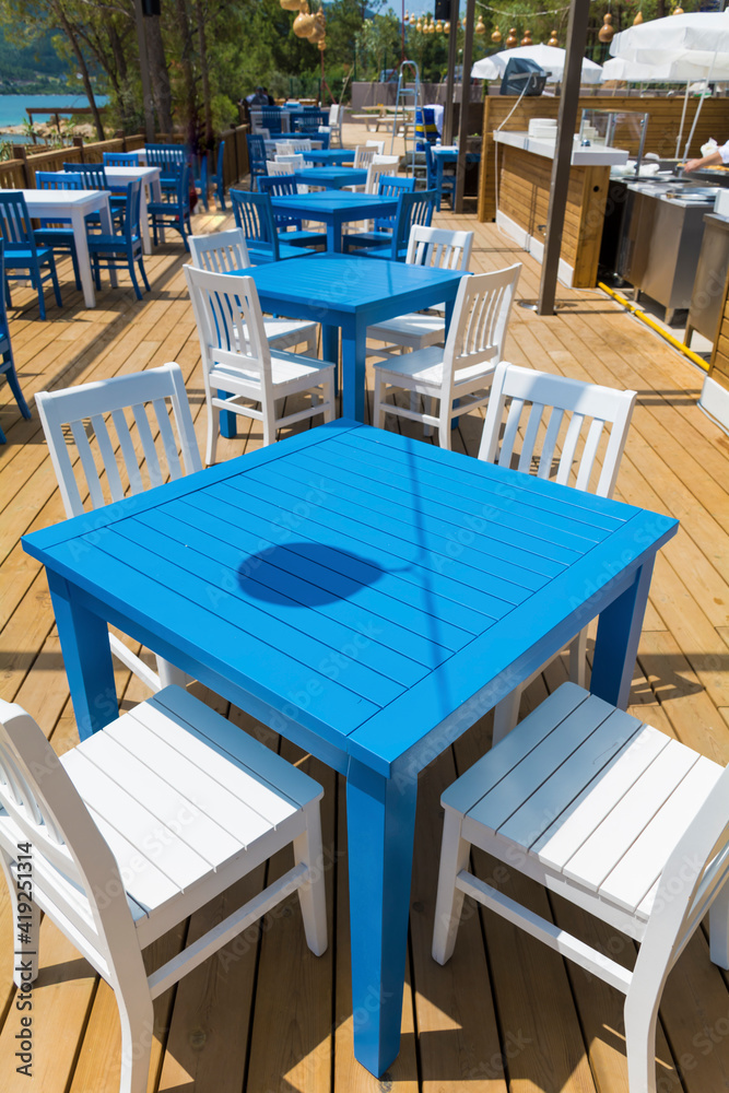 Outdoor  Greek  Restaurant with Blue Tables and White Chairs