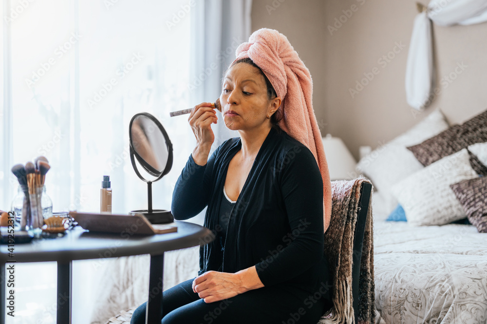 40-year-old woman applying makeup after taking a shower