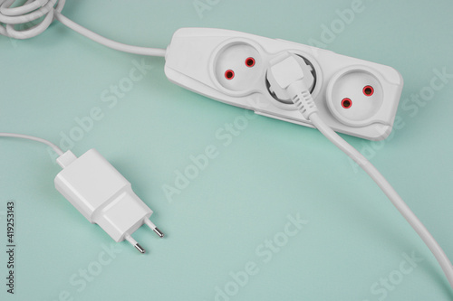 Stylish white extension with sockets on tiffany background . Electrical power white strip or extension block. Many wires and sockets. High-tech smart strip. Close up.