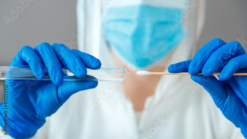 Covid 19 pcr test in nurse hands. Doctor in protective suit medical mask gloves holding Swab saliva sample for diagnostic covid19 coronavirus virus in lab. Nasopharyngeal culture pcr test. Web Banner