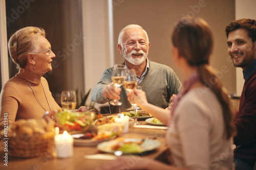 Happy senior man toasting during family dinner at dining table.