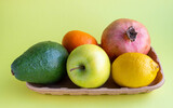 A small collection of fresh fruits in eco-friendly packaging on a yellow background