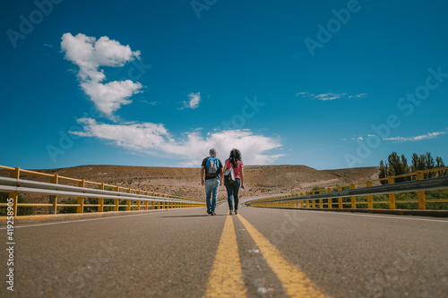 Traveler couple with backpack walking on route in Patagonia Argentina