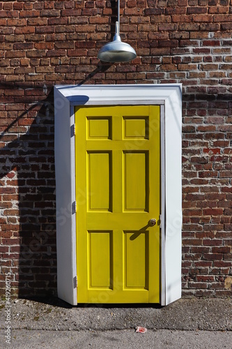 old yellow wooden door in a brick wall