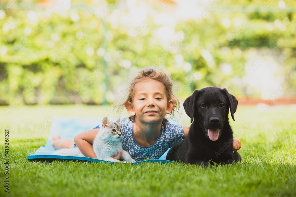 Cute preschool girl play with pets on fresh grass Cute preschool girl play with pets on fresh grass