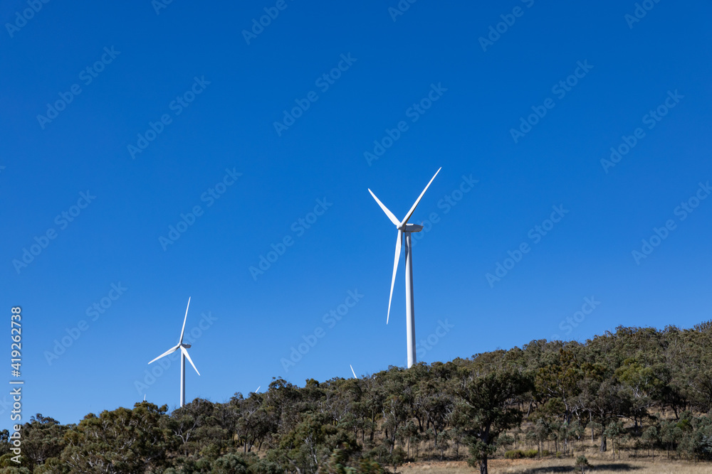 Electricity generating windmill Farms Hume Highway NSW Australia taken from moving car blurred foreground Electricity generating windmill Farms Hume Highway NSW Australia taken from moving car blurred foreground