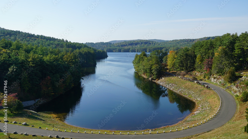Fototapeta premium Overlook of beautiful peaceful lake surrounded by mountains in early autumn.