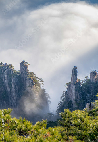View of the clouds and the pine tree at the mountain peaks of Huangshan National park  China. Landscape of Mount Huangshan of the winter season.