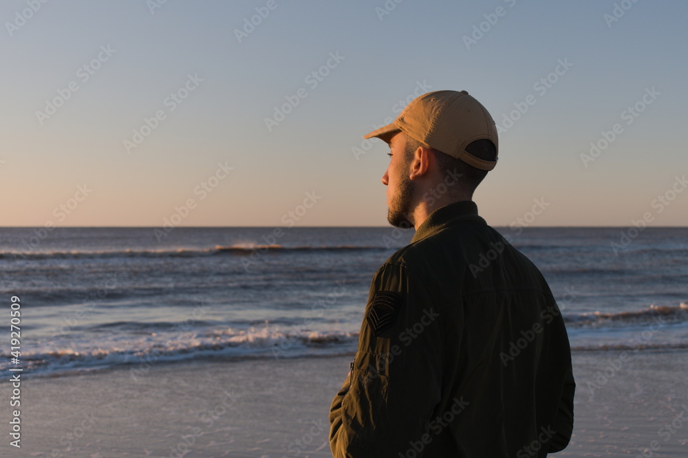thoughtful man on the beach at sunrise