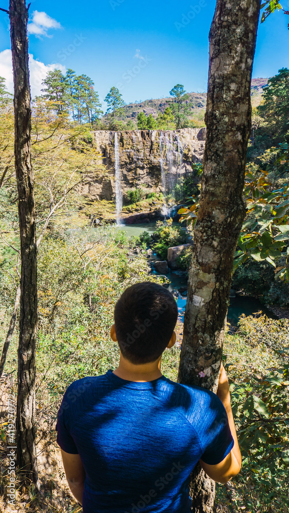 Man looking at the waterfall in Honduras Central America