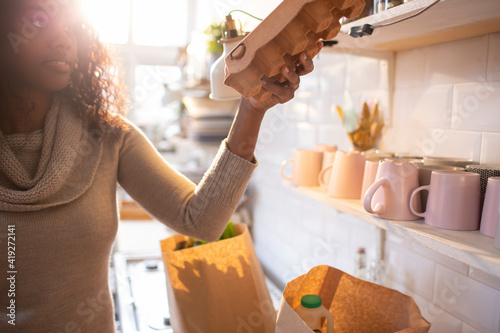 Woman unloading groceries in kitchen