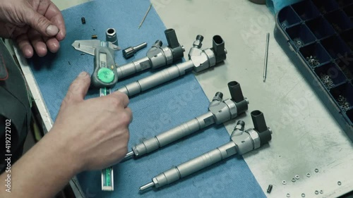 Engine injector repair. Male mechanical measuring elements nozzle caliper. Close-up.