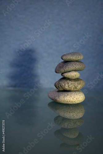 Tower of river stones for spa with reflection on glass