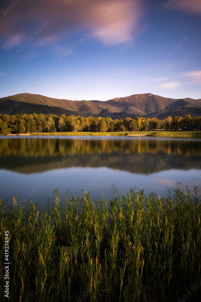 A summer evening at Lake Arrowhead as Shenandoah National park reflects in the calm lake near Luray, Virginia.