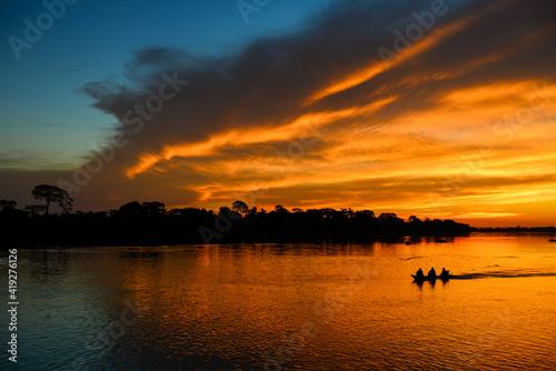 A boat during sunset on the Guaporé-Itenez river, Guaporé River Indigenous Land, Rondônia state, Brazil - Bolivia border photo
