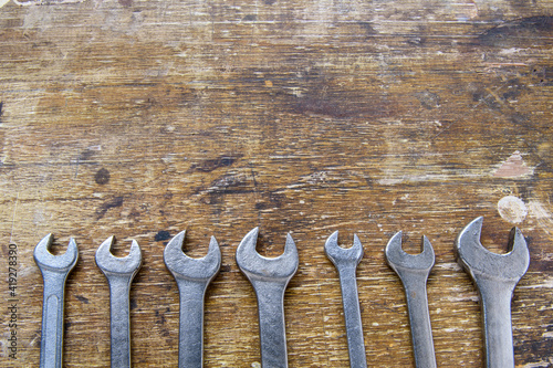 Set of wrench aligned on rustic wood photo