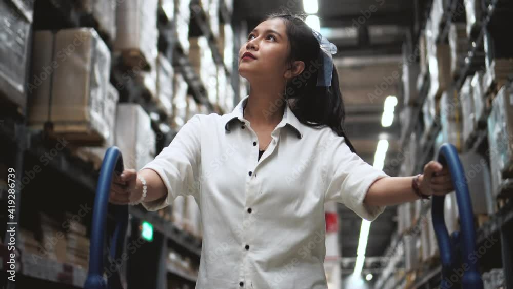 Asian woman with shopping cart walking for choosing new furniture in big store warehouse. Asian woman with shopping cart walking for choosing new furniture in big store warehouse.