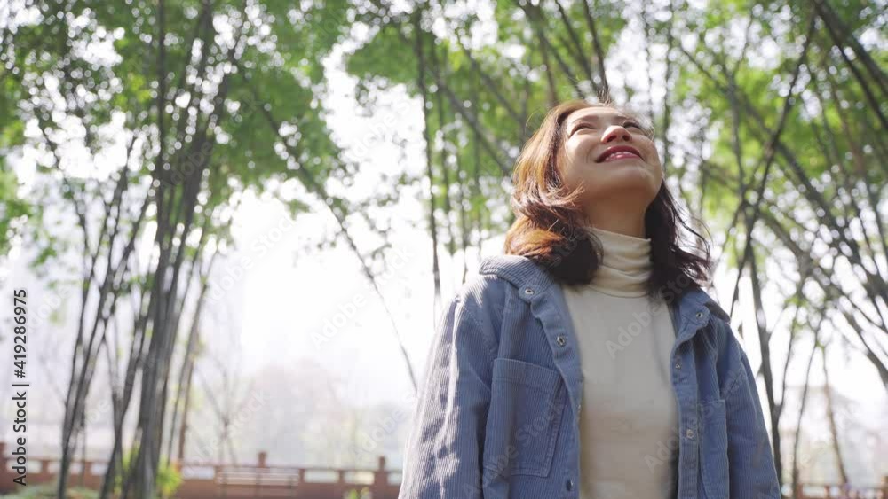 4k slow motion of Young beautiful Chinese girl enjoys the spring sunshine Young Asian women smiling and looking up smile in the bamboo forest Healthy lifestyle concept people love the nature 4k slow motion of Young beautiful Chinese girl enjoys the spring sunshine Young Asian women smiling and looking up smile in the bamboo forest Healthy lifestyle concept people love the nature