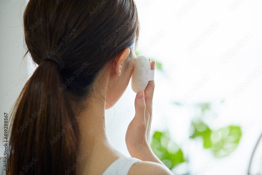 リビングでメイクをする若い女性