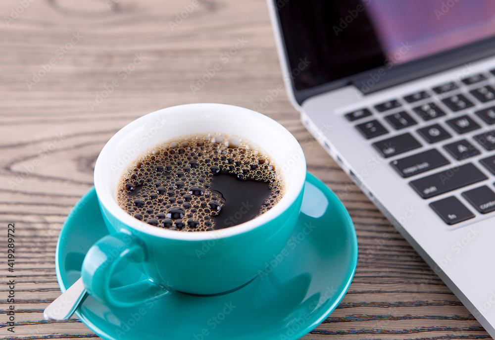 A cup of coffee next to the notebook A cup of coffee next to the notebook