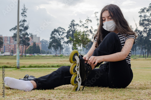 girl putting on roller skate and wearing a mask