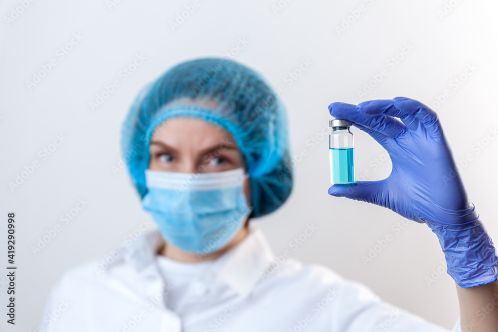Doctor in gloves and mask holds bottle with vaccine, medicine Doctor in gloves and mask holds bottle with vaccine, medicine