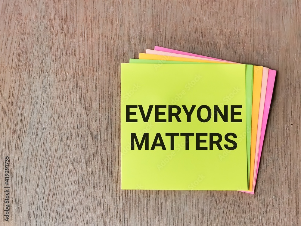 Phrase EVERYONE MATTERS written on sticky note isolated on wooden background. Phrase EVERYONE MATTERS written on sticky note isolated on wooden background.