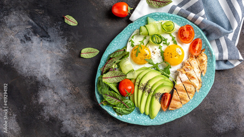 Ketogenic paleo diet. Chicken grilled fillet with salad fresh tomatoes, cucumbers, eggs and avocado. Keto breakfast. banner, menu recipe place for text, top view