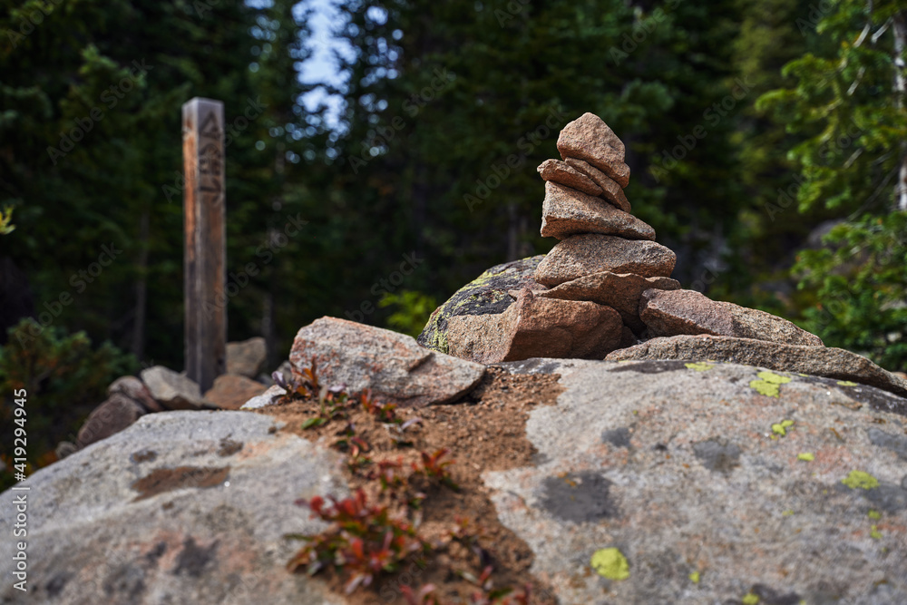 A cairn rock stack placed by a Colorado trail marker.