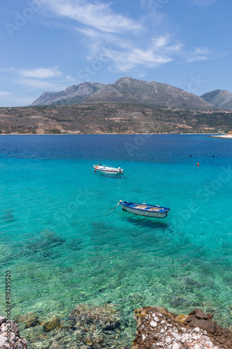 view of  Limeni village with fishing boats in  turquoise waters and the stone buildings as a background  in Mani, South Peloponnese , Greece. © valantis minogiannis