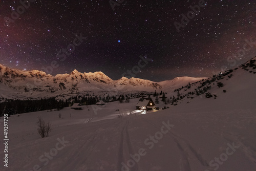 Fototapeta Naklejka Na Ścianę i Meble -  Night winter landscapes in the High Tatras, with mountain houses on a background of snow-capped mountains and starry sky