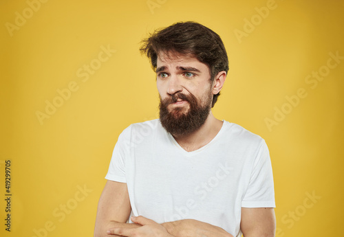 The man has his arms crossed over his chest against a yellow background cropped view