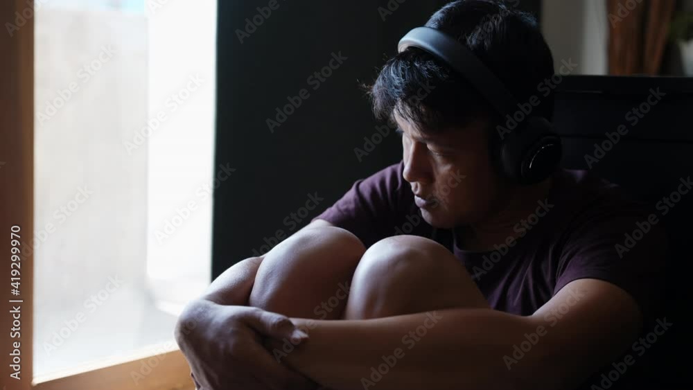 Vidéo Stock 4K Depressed Asian man sit on the floor by window with ...