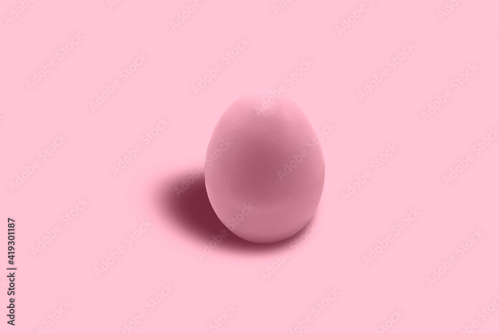 A chicken egg painted pink in close-up on a pink background. Free space. Minimalism. Pink on pink.