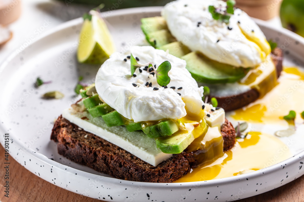 Sandwich with avocado and Poached Egg. Wholemeal Bread Toast sliced avocado and egg with cup of coffee for healthy breakfast or snack Sandwich with avocado and Poached Egg. Wholemeal Bread Toast sliced avocado and egg with cup of coffee for healthy breakfast or snack