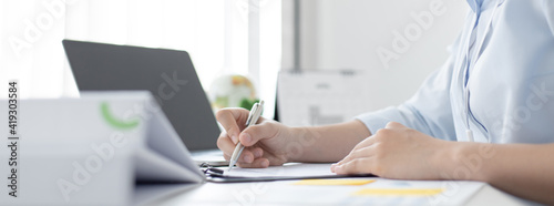 Foto Asian women are analyzing graphs, market data and assessing investment risks, Working at home during the outbreak of the virus or social spacing, Refraining from spreading germs