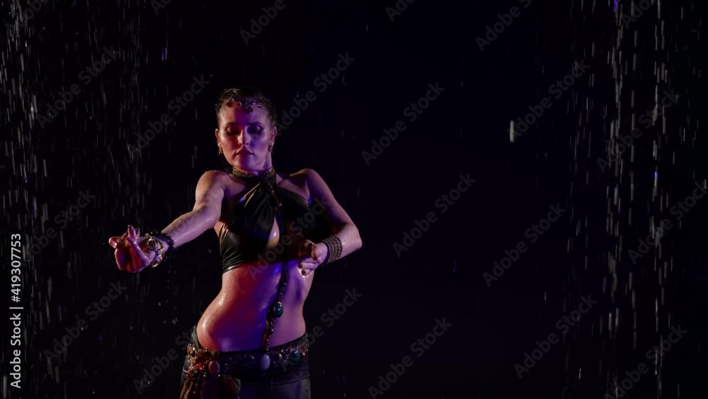 sexy woman is dancing belly dance in darkness, standing under water flows, sexuality sexy woman is dancing belly dance in darkness, standing under water flows, sexuality