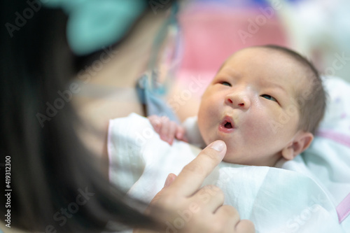 Canvas Print Closeup on the face of the baby in the arms of the mother and pouting with her l