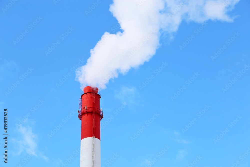 Factory chimney on blue sky background with white smoke. Concept of steam plant, air pollution, heating season Factory chimney on blue sky background with white smoke. Concept of steam plant, air pollution, heating season