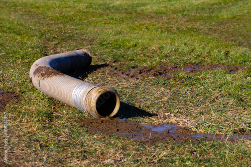 Photography Big tube with slurry or manure is laying in the grass