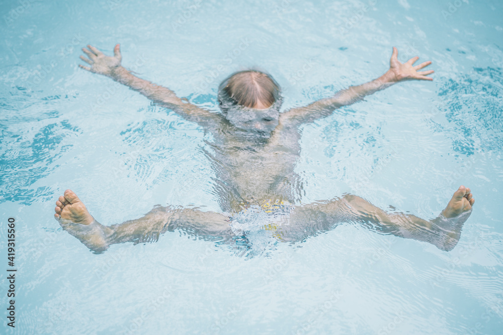 Simplicity innocence easy lifestyle collection. Time to stop worry even in crisis, follow the example of children. Wet kid swim in pool, dives sink in water, open arms legs like star. Happy childhood