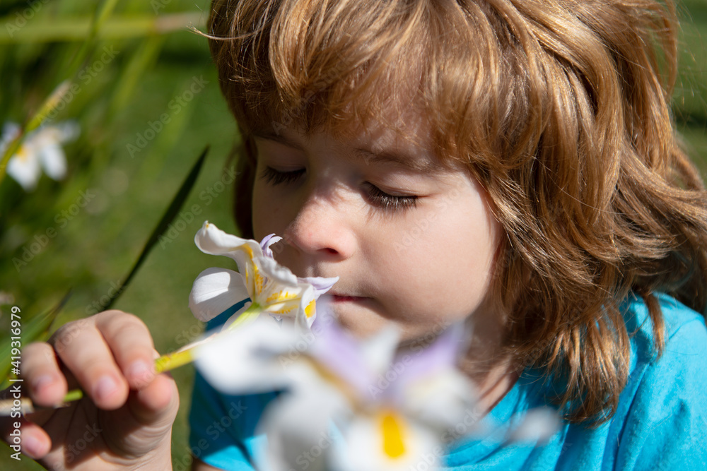 Happy childhood. Spring kid sniffs flowers. Allergy free concept. Cute child in blossom park. Happy childhood. Spring kid sniffs flowers. Allergy free concept. Cute child in blossom park.