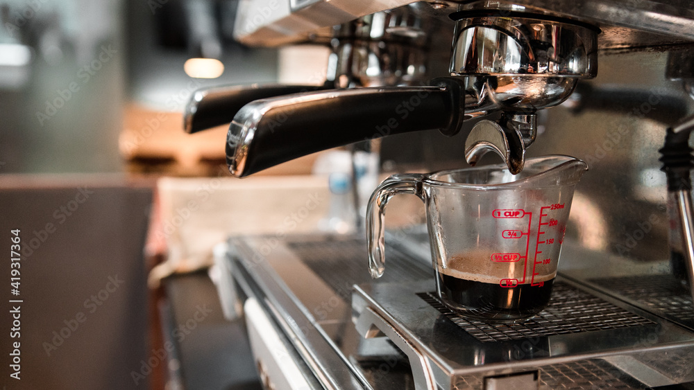 black coffee in measuring cup put on coffee maker